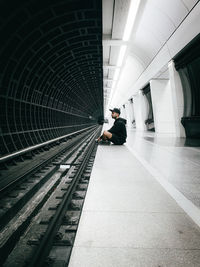 Man sitting on railroad station platform