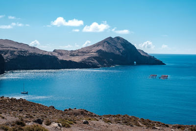 Scenic view of sea and mountains against sky