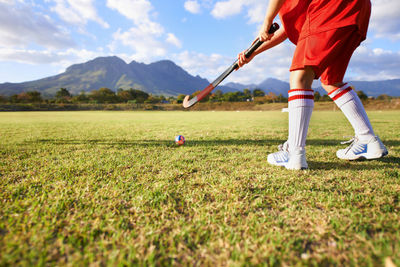 Low section of man standing on field