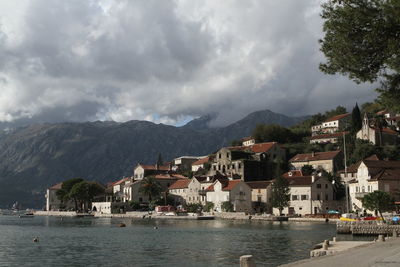 Scenic view of river by buildings against sky