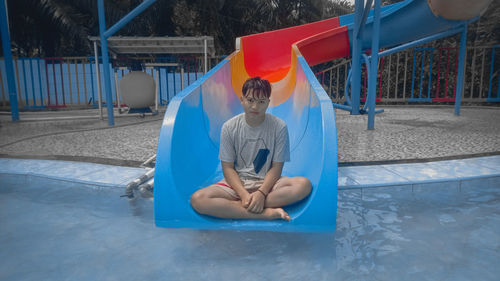 Boy playing in swimming pool at playground