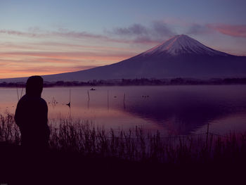 Silhouette view from 25s to 35s man see sunrise from kawaguchi lake and fuji mountain