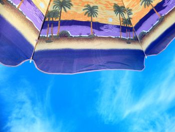 Low angle view of palm trees against blue sky