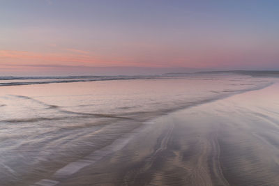 Scenic view of beach against sky during sunset