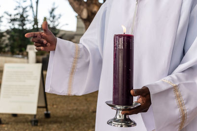 Seminarian carries a seven-day candle on the day of the dead holiday at the campo santo cemetery