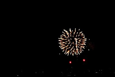 Low angle view of fireworks against sky at night