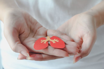 Midsection of woman holding heart shape