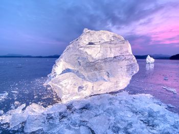 Detail of an ice with deep scratches and cracks. cut floe against to evening sky and spot light.