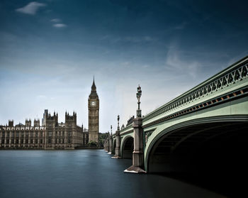 Westminster bridge over river leading towards big ben against sky in city
