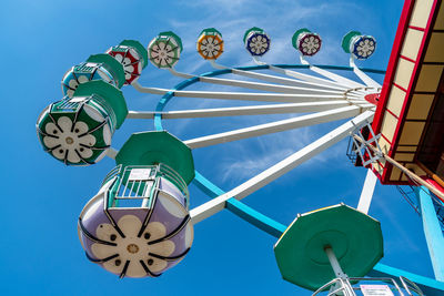 Low angle view of amusement park ride against blue sky