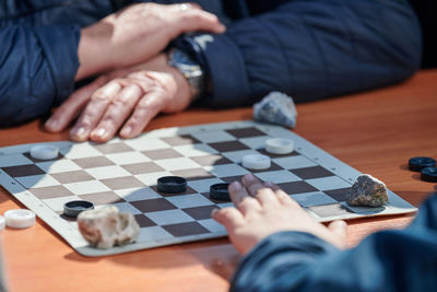 Midsection of man playing chess on table