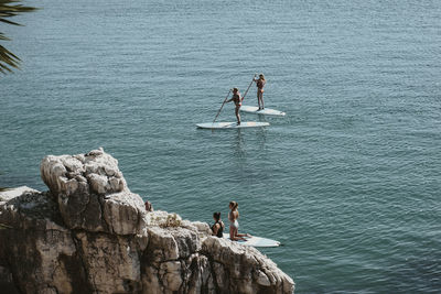 High angle view of people on rock by sea