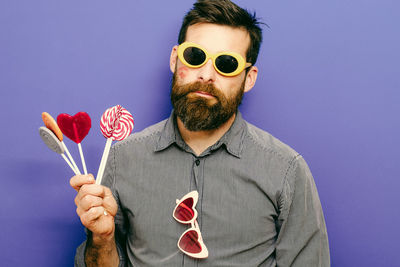 Portrait of man wearing sunglasses against gray background