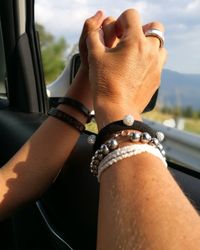 Close-up of hand holding car against sky