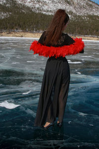 Rear view of woman standing at beach