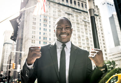 Portrait of a smiling young man against building in city