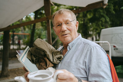 Portrait of senior male customer shopping at flea market