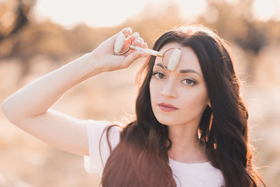 Woman make massage with facial stone roller over sunny nature background closeup. healthy lifestyle