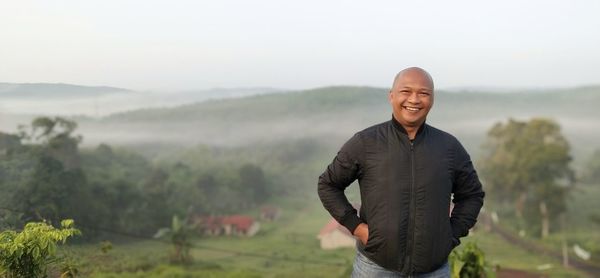 Portrait of man standing against mountain