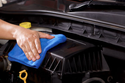 Cloth worker cleaning the car engine room