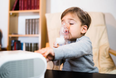 Boy using respiratory machine at home