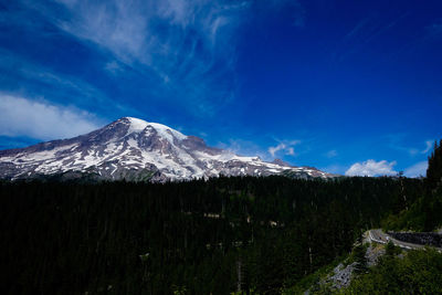 Scenic view of snowcapped mountains against blue sky