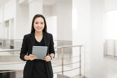 Portrait of businesswoman holding digital tablet at office