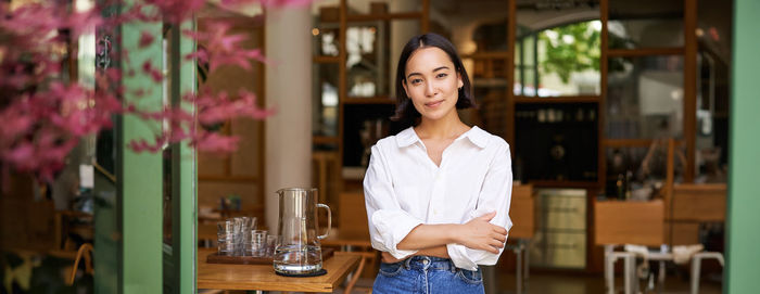 Portrait of young woman standing in supermarket