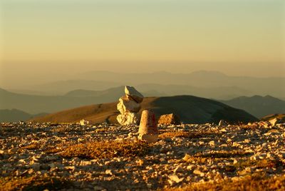 Rocks stacked on mountain against sky during sunset