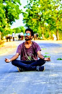 Young man sitting on sunglasses