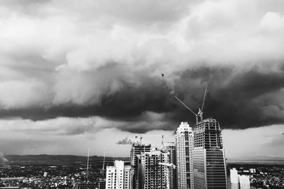 Low angle view of skyscrapers against cloudy sky
