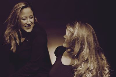 Close-up of smiling friends in darkroom