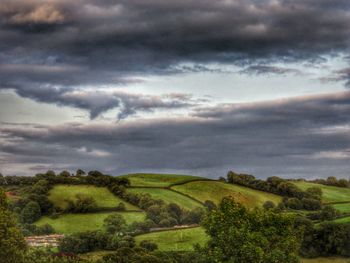 Scenic view of field against cloudy sky