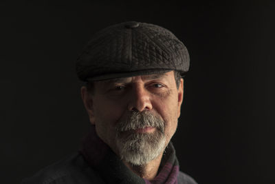 Portrait of man against black background