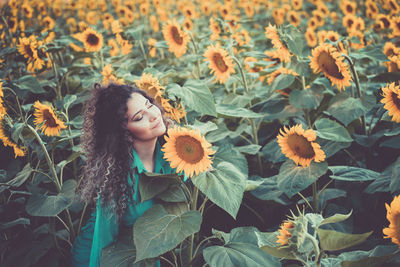 Young woman relaxing in sunflower field