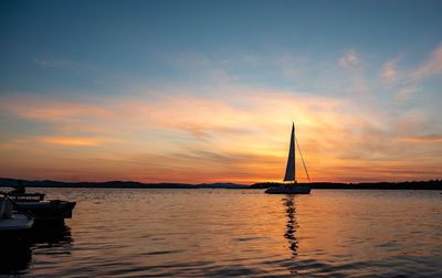 Sailboat sailing on sea against sky during sunset