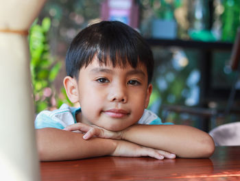 Portrait of cute boy looking away at home