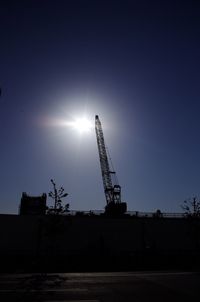 Low angle view of crane against sky