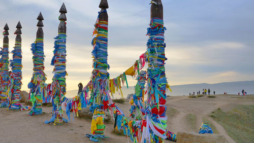 Multi colored flags on beach against sky