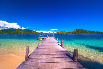 Pier over sea against blue sky