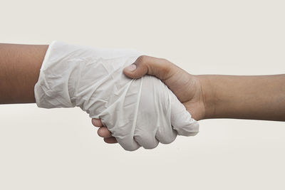 Close-up of man holding hands over white background