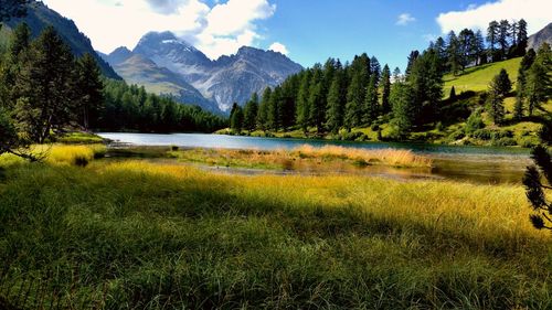 Scenic view of lake by mountains against sky