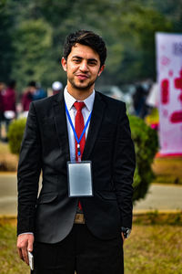 Portrait of young businessman standing outdoors