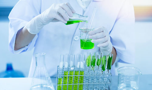 Midsection of scientist examining chemical in laboratory