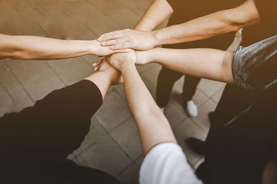 High angle view of friends stacking hands