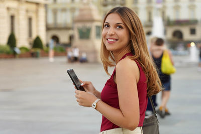 Candid thoughtful girl holds mobile phone for shopping online e-commerce outdoor. copy space.