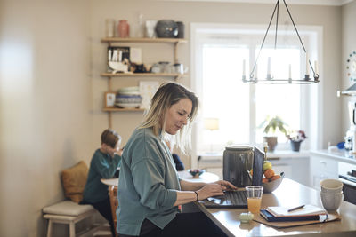 Smiling female freelancer working on laptop at home