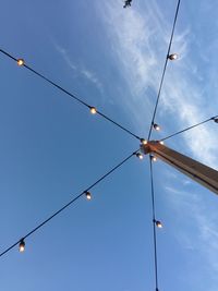 Low angle view of power lines against blue sky