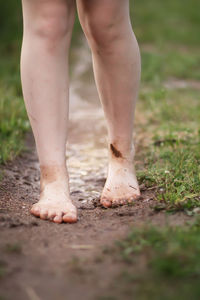 Low section of standing in puddle by grass outdoors
