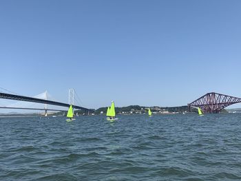 Bridge over sea against clear blue sky